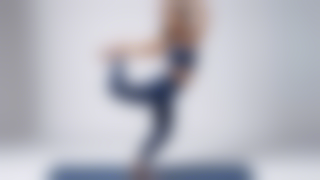 A graceful dancer moves through effortless leaps and glides, clad in the perfect yoga pants for both comfort and style. The pants are a rich deep blue, with subtle details that catch the light as she 